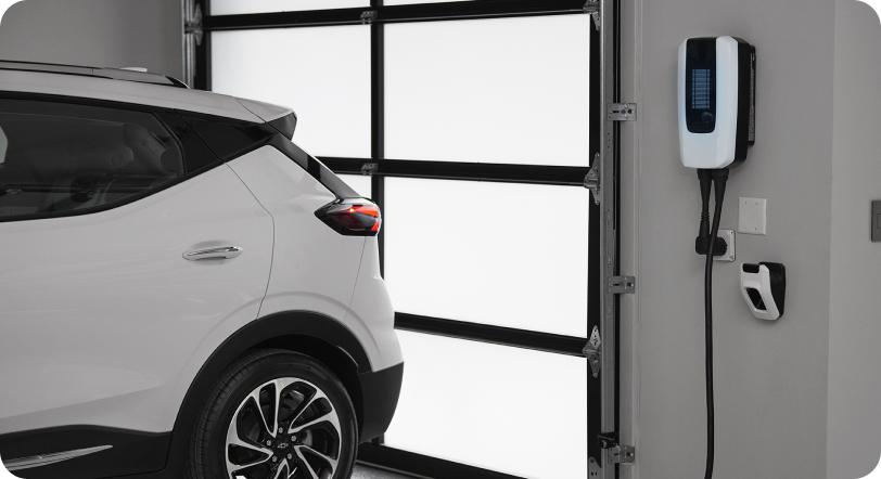 Electric vehicle parked in garage next to wall charger.