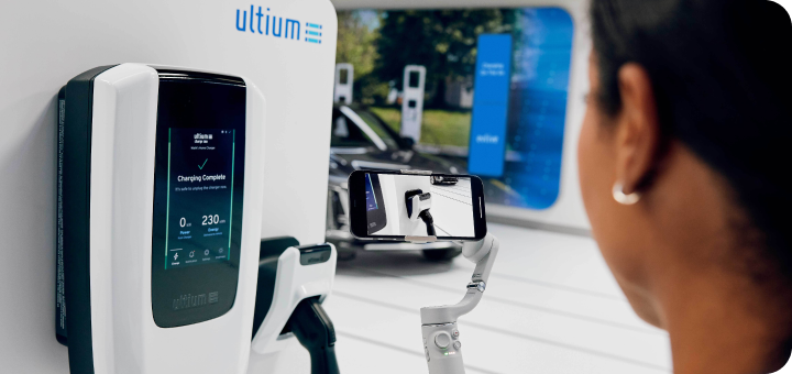 Woman at a charging station looking at the Ultium EV charging unit before using it.
