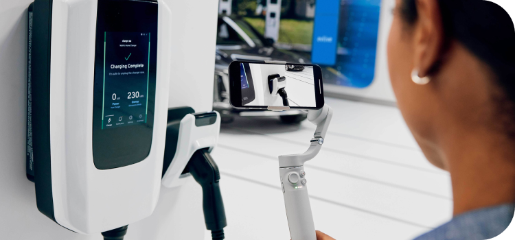 Woman at a charging station looking at the Ultium EV charging unit before using it.