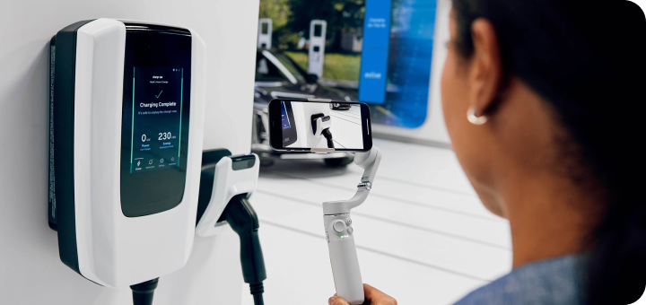 Woman at a charging station looking at the Ultium EV charging unit before using it.
