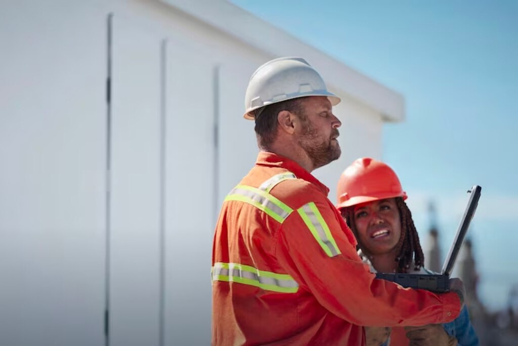 Two workers in hard hats and safety gear