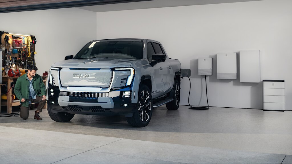 Man in garage with EV truck with the GM Energy product suite